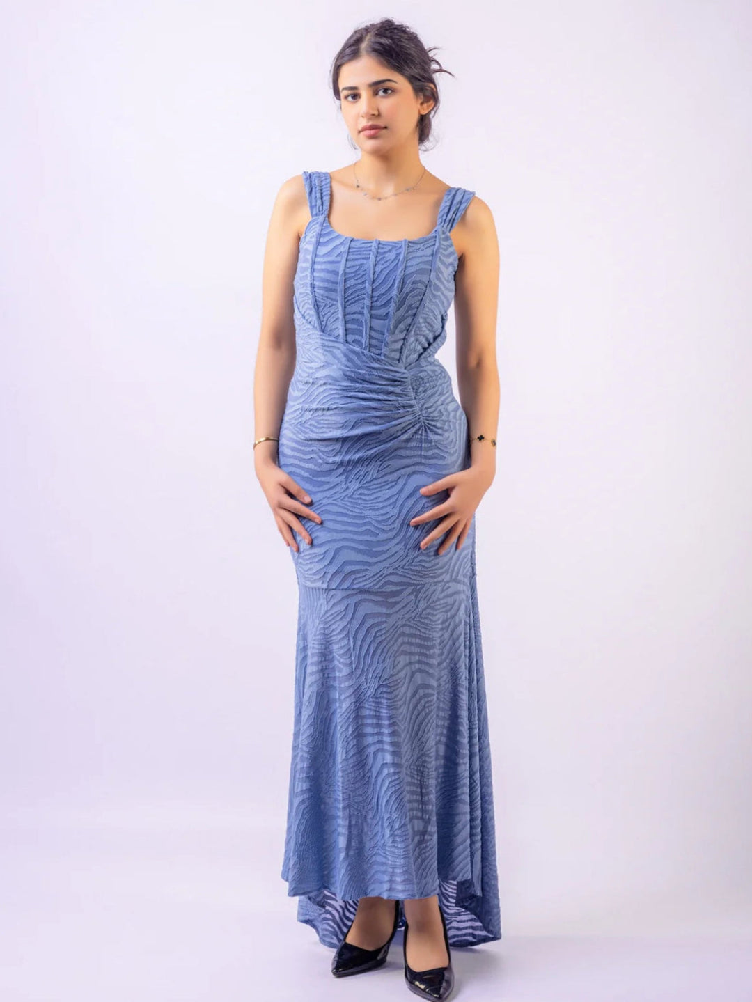 Woman wearing a blue patterned dress on a white background