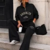 EA-TE536-2 Honoria black co-ord, seated view showing wide trouser legs and drawstring waist