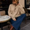 Alix floral-placket jumper, seated view showing relaxed sleeves and ribbed cuffs