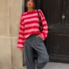 EA-TE567-5 Amelie red and pink long-sleeve T-shirt on a model leaning by a doorway, front view