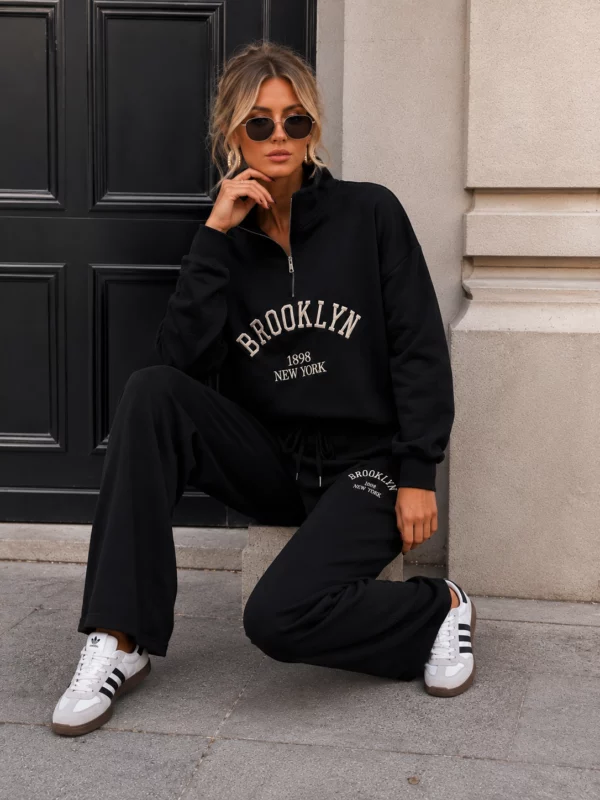 EA-TE536-3 Honoria black slogan set, close seated view of zip collar and chest lettering