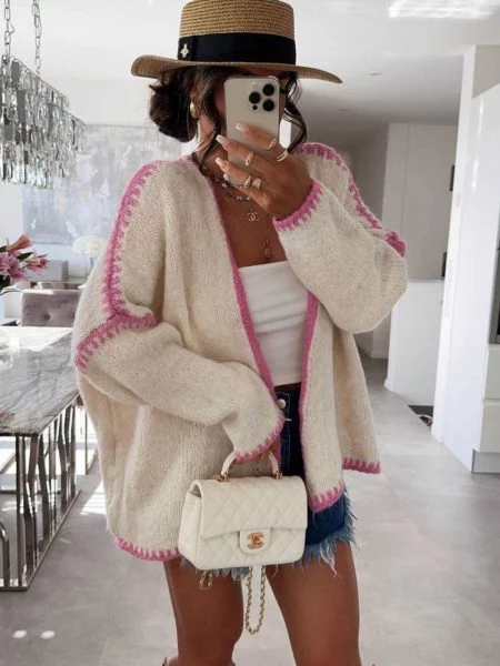 Estella cream open knitted cardigan with pink stitch-style borders on a model